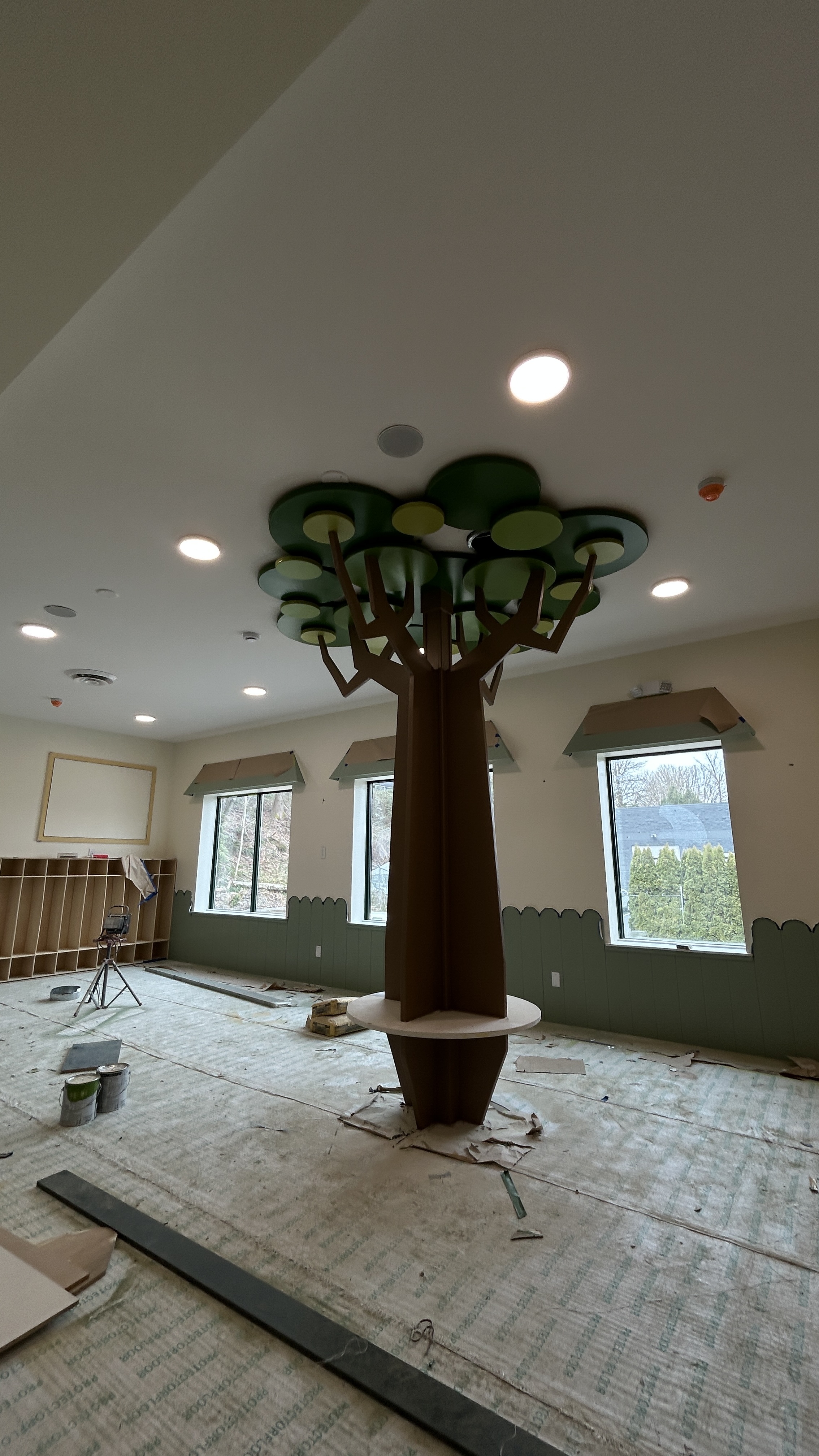 Full-size decorative tree installation in a daycare space