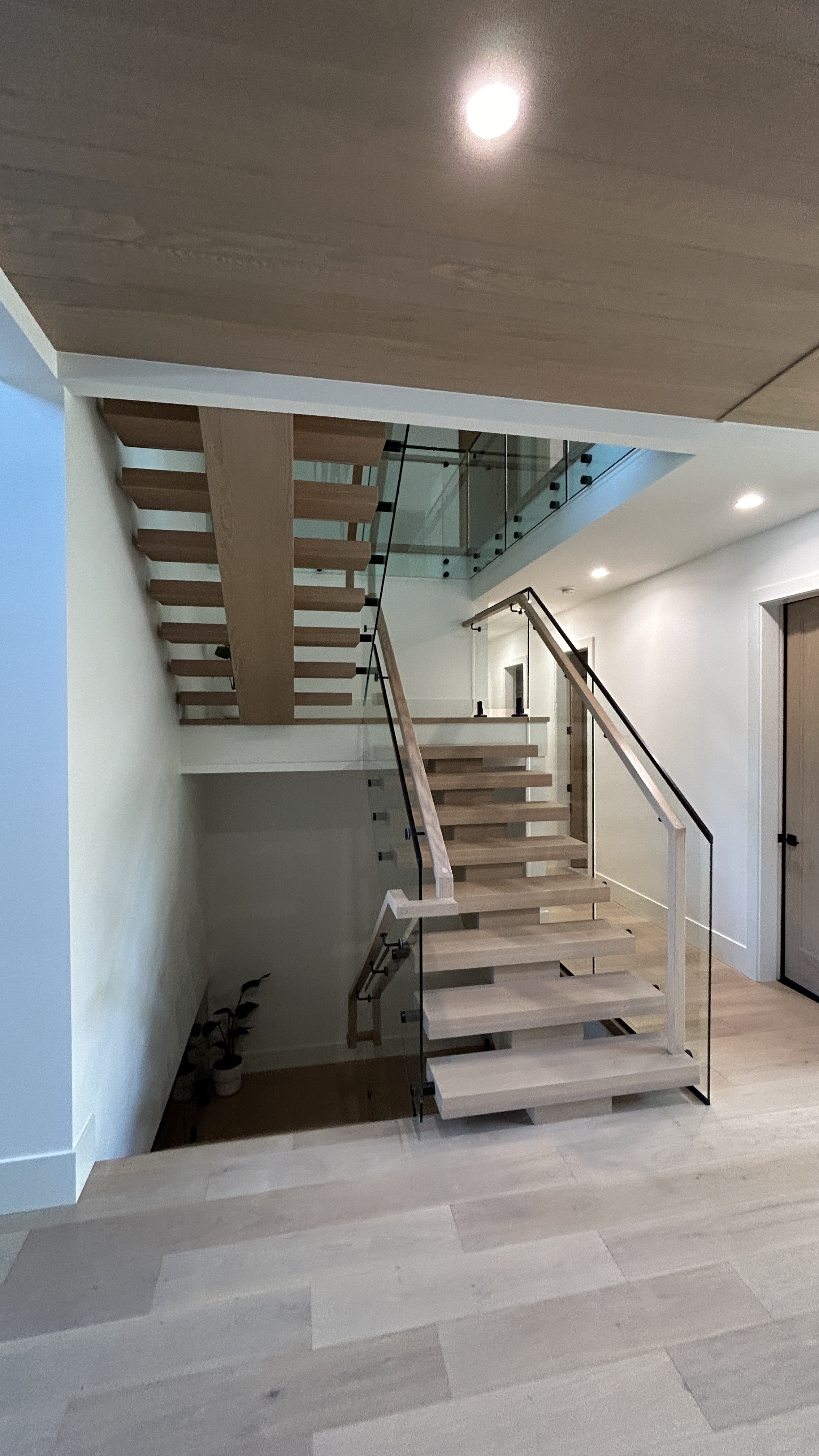 Modern floating staircase with glass railing and wood treads